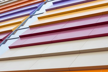 Colorful abstraction of the facade of the building. Beautiful and iridescent colors of solid metal are used in modern construction.