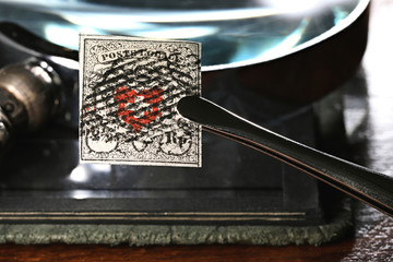 Swiss 2 1/2 Rappen Poste Locale stamp from 1850 held by tweezers.