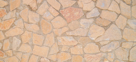 Masonry wall of stones with irregular pattern texture background