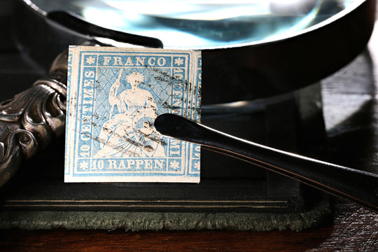 Swiss 10 Rappen Strubel stamp held by tweezers.