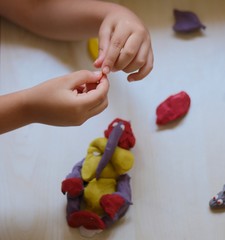 kids playing with play dough over white background