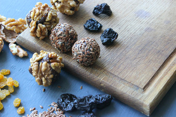 Homemade healthy raw vegan sweet balls with nuts,raisins, dates, cocoa and flax seeds. Healthy vegan food concept. Gray background.