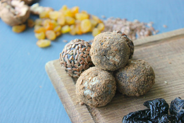 Obraz na płótnie Canvas Homemade healthy raw vegan sweet balls with nuts,raisins, dates, cocoa and flax seeds. Healthy vegan food concept. Gray background.
