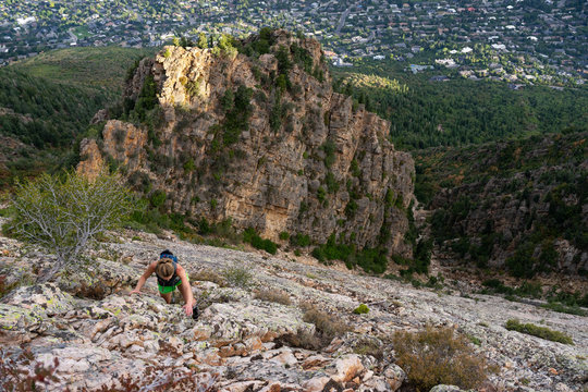 Blonde Woman Rock Climbing Above Suburban Neighborhood