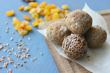 Homemade healthy raw vegan sweet balls with nuts,raisins, dates, cocoa and flax seeds. Healthy vegan food concept. Gray background.