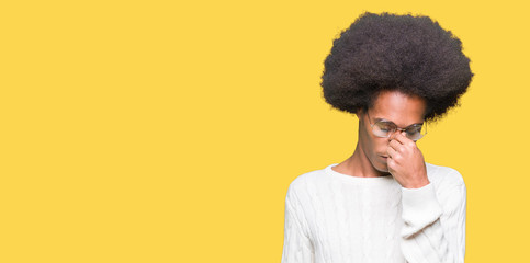 Fototapeta na wymiar Young african american man with afro hair wearing glasses tired rubbing nose and eyes feeling fatigue and headache. Stress and frustration concept.