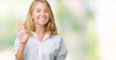 Beautiful young business woman over isolated background Waiving saying hello happy and smiling, friendly welcome gesture