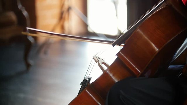 A woman playing the cello in the studio
