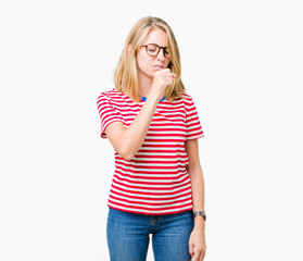 Beautiful young woman wearing glasses over isolated background feeling unwell and coughing as...
