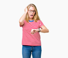 Beautiful young woman wearing glasses over isolated background Looking at the watch time worried, afraid of getting late