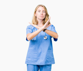Beautiful young doctor woman wearing medical uniform over isolated background Rejection expression...