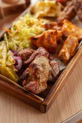 Macro close up of assorted grilled meat snacks: chicken, beef and lamb kebab, roasted pork shish kebab, served with coleslaw