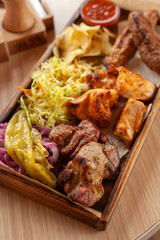 Macro close up of assorted grilled meat snacks: chicken, beef and lamb kebab, roasted pork shish kebab, served with coleslaw