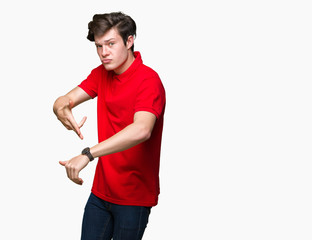 Young handsome man wearing red t-shirt over isolated background In hurry pointing to watch time,...