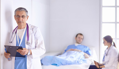 Doctor checking heart beat of patient in bed with stethoscope