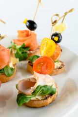 Close up of canape with wheat bread, greens and smoked chicken as an appetizer for party buffet or banquet isolated on white