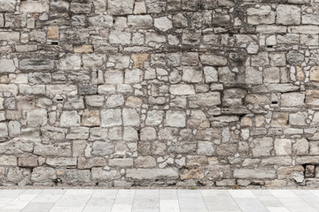 Gray rough stone wall and white floor tiling