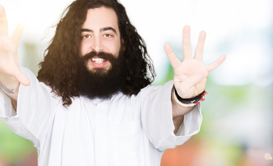 Man wearing Jesus Christ costume showing and pointing up with fingers number nine while smiling confident and happy.