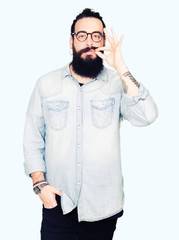 Young hipster man with long hair and beard wearing glasses mouth and lips shut as zip with fingers....