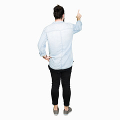 Young hipster man with long hair and beard wearing glasses Posing backwards pointing behind with finger hand