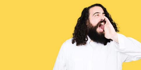 Man wearing Jesus Christ costume shouting and screaming loud to side with hand on mouth. Communication concept.