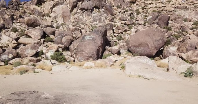 dolly in shot approaching stones and rock formations of Mojave mountains