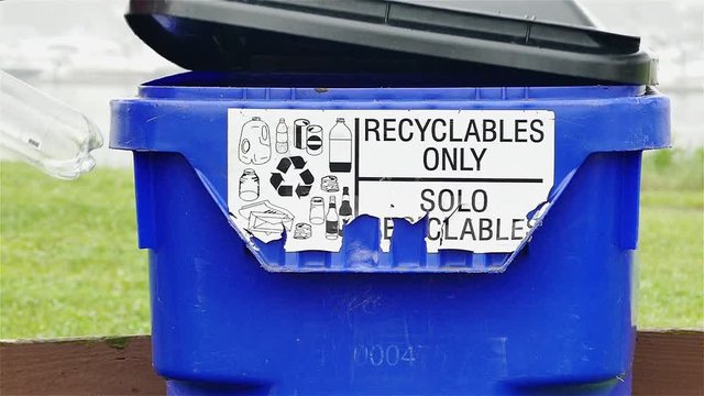 Man is adding plastic bottle to recycling bin slow motion