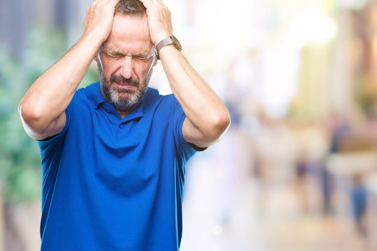 Middle age hoary senior man over isolated background suffering from headache desperate and stressed because pain and migraine. Hands on head.