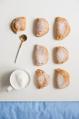 Delicious homemade dessert. Shortbread sweet with coffee in a white mug. teaspoon golden. On a white background.