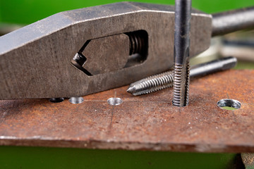 Manual thread cutting in metal. Locksmith accessories for small work in the home workshop.