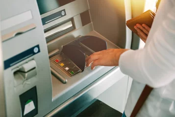 Foto op Aluminium Woman using ATM holding wallet an pressing the PIN security number on the keyboard automatic teller machine © ifeelstock