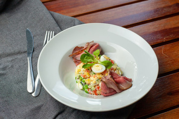 Fancy salad with thai style marbled beef with greens, crunchy cucumber, bell pepper and green peas