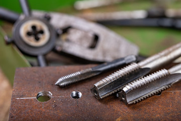 Manual thread cutting in metal. Locksmith accessories for small work in the home workshop.