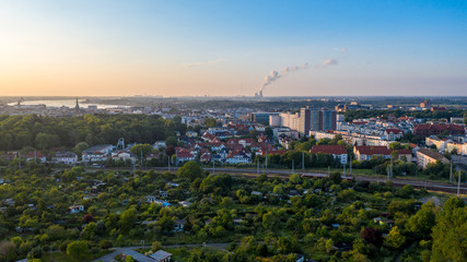 aerial view of the city of rostock, railway tracks, river warnow and power plant chimney in the background