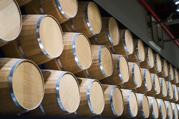 Wine barrels in wine-vaults in order, close-up. Stacked wine barrels
