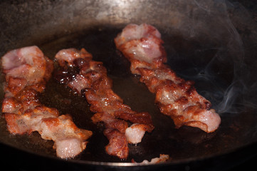 Sizzling hot bacon in a cast iron skillet