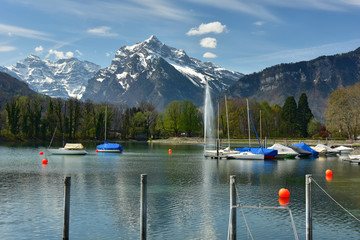 Boats moored on the Walensee lake. View of the Alps. Village of Weesen, Switzerland.