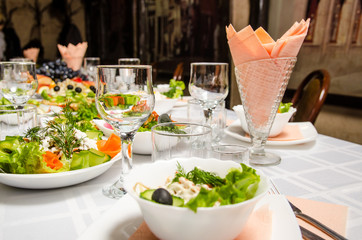 table lined with variety of dishes and empty vineglasses