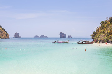 Fototapeta premium Longtail boats mooring on the beach at Tub island is Thale waek or separated sea in crystal clear water and miracle beach andaman sea Krabi, Thaiand 
