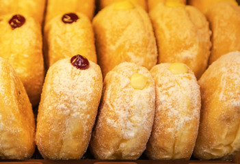 Close up row of sweet golden donuts with jam for breakfast