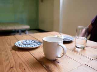 Coffee and cake on wooden table after the cake has been eaten