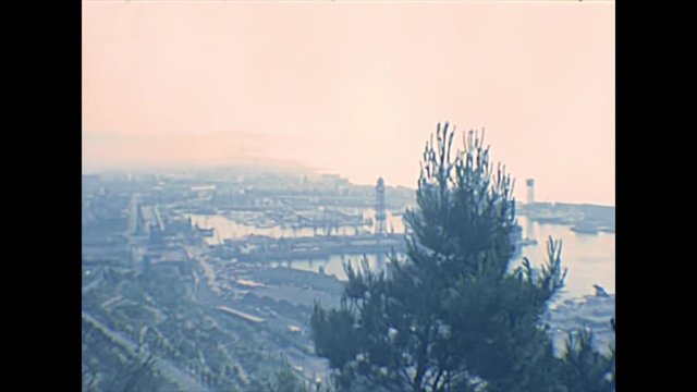 Panorama of Barcelona city from the walls of the Montjuic Castle, an old military fortress of Catalonia region overlooking Barcelona. Historical archival aerial view of Spain in 1970s.