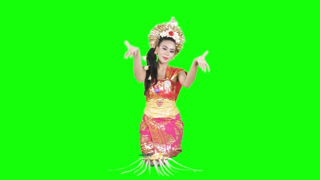 Beautiful balinese dancer performing while sitting in the studio. Shot in 4k resolution with green screen background