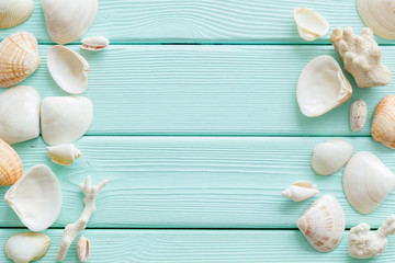 Summer at the sea design for blog with shells frame on mint green wooden background top view copy space