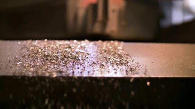 Small Scrap Metal Pieces Sliding Along Vibrating Metal Ramp Into Bin