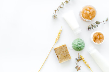 Scrabs and creams for natural cosmetic set with herbs and wheat on white background top view mock up