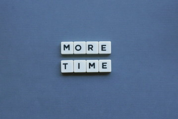 ' More Time ' word made of square letter word on grey background.