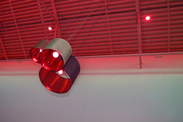 Ultra-modern loft style in red toned color decorative lamps and lampshades hang on a long rope,...