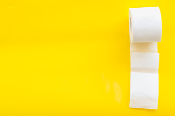 Toilet paper roll on yellow background top view copy space