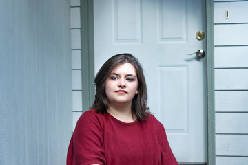 girl sits in front of blue and green door